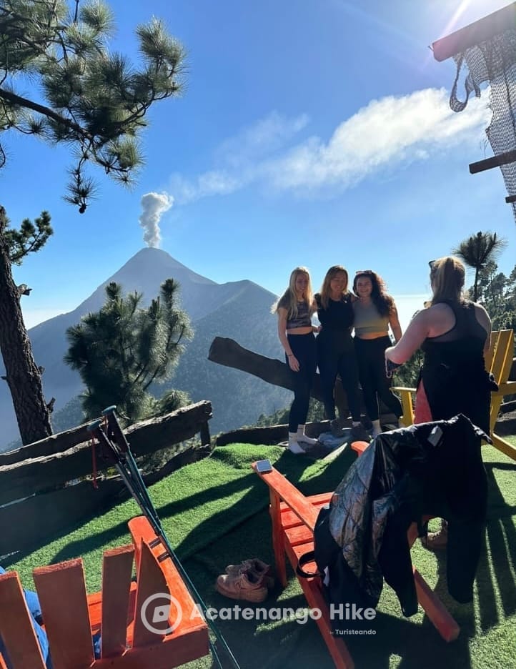 Travelers at the base camp with Volcán de Fuego smoking behind them