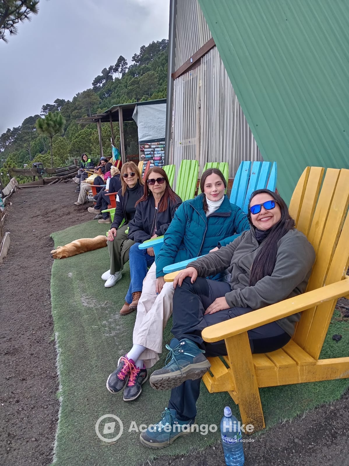 Viajeros descansando en sillas de colores en el campamento base